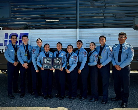 Explorers posing at a state competition holding two first place trophies
