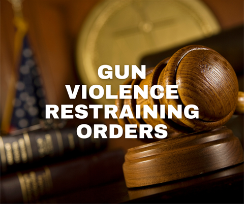 image of a gavel sitting next to a book on a judge's desk with the wording gun violence restraining orders